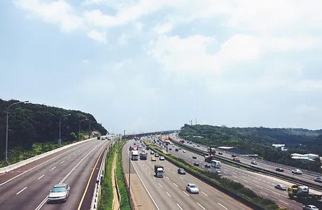 A highway with many cars on it and some trees